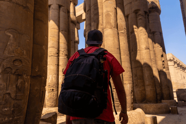 Person exploring ancient Egyptian temple columns.