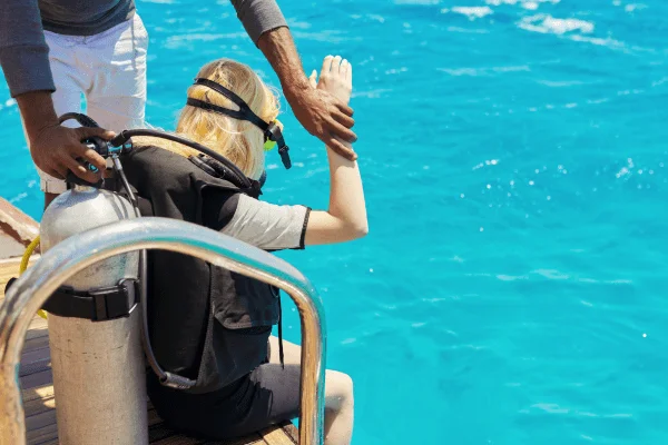 Diver preparing for scuba dive in tropical sea.