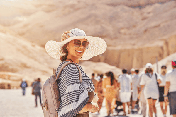Woman smiling in a sunny desert setting.