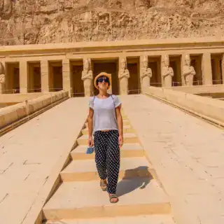 Person walking at ancient Egyptian temple site.