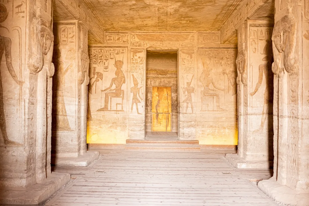 Interior view of an ancient Egyptian temple with hieroglyphics and carved pillars.