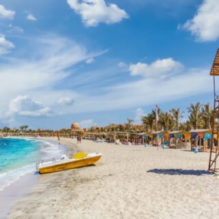 Sunny beach with a lifeguard tower and boat Abu Dabbab Dugong Bay Snorkeling