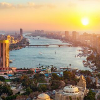 Cairo skyline at sunset over the Nile River.