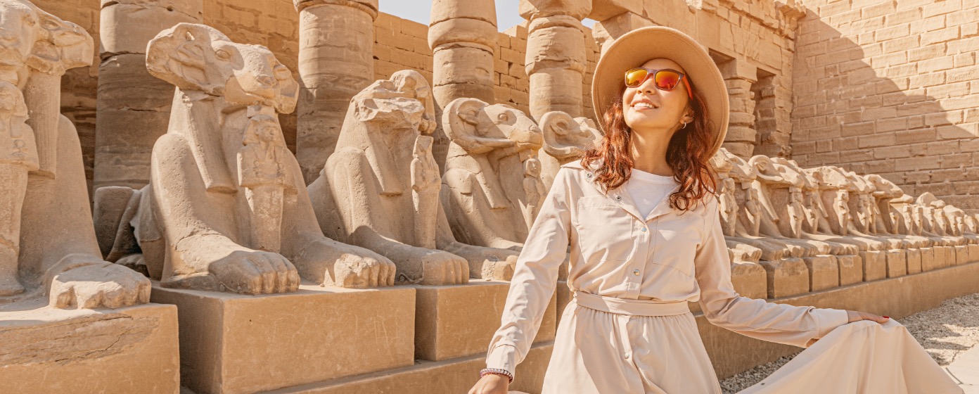 Woman Enjoying Ancient Egyptian Temple Sculptures During An Egypt Dmc Group Tour In Luxor.