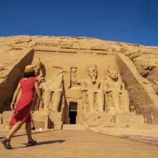 A European tourist in red dress at the Abu Simbel Temple in southern Egypt