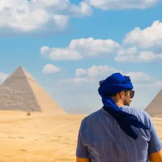 A young girl in a red dress at the pyramid of Cheops the largest pyramid at sunset