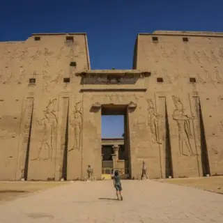 A young tourist at the entrance to the Edfu Temple near the Nile River in Aswan