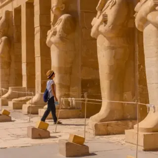 A Young Woman With Pharaoh Sculptures Entering Hatshepsut'S Funerary Temple In Luxor. Egypt