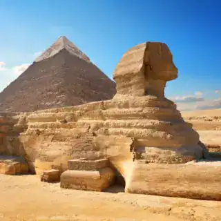 Ancient Sphinx with Pyramid behind it being admired by tourist on an Egypt DMC group tour.