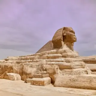 Majestic sphinx sculpture stands guard in front of the iconic pyramids of Giza, Egypt.