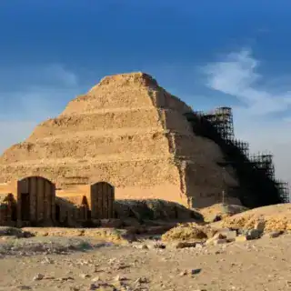Step Pyramid of Djoser in Saqqara under restoration with clear blue sky.