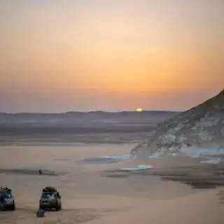 a couple of trucks that are sitting in the sand