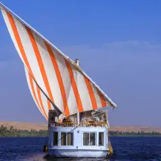 Traditional Dahabiya sailing at sunset on the Nile